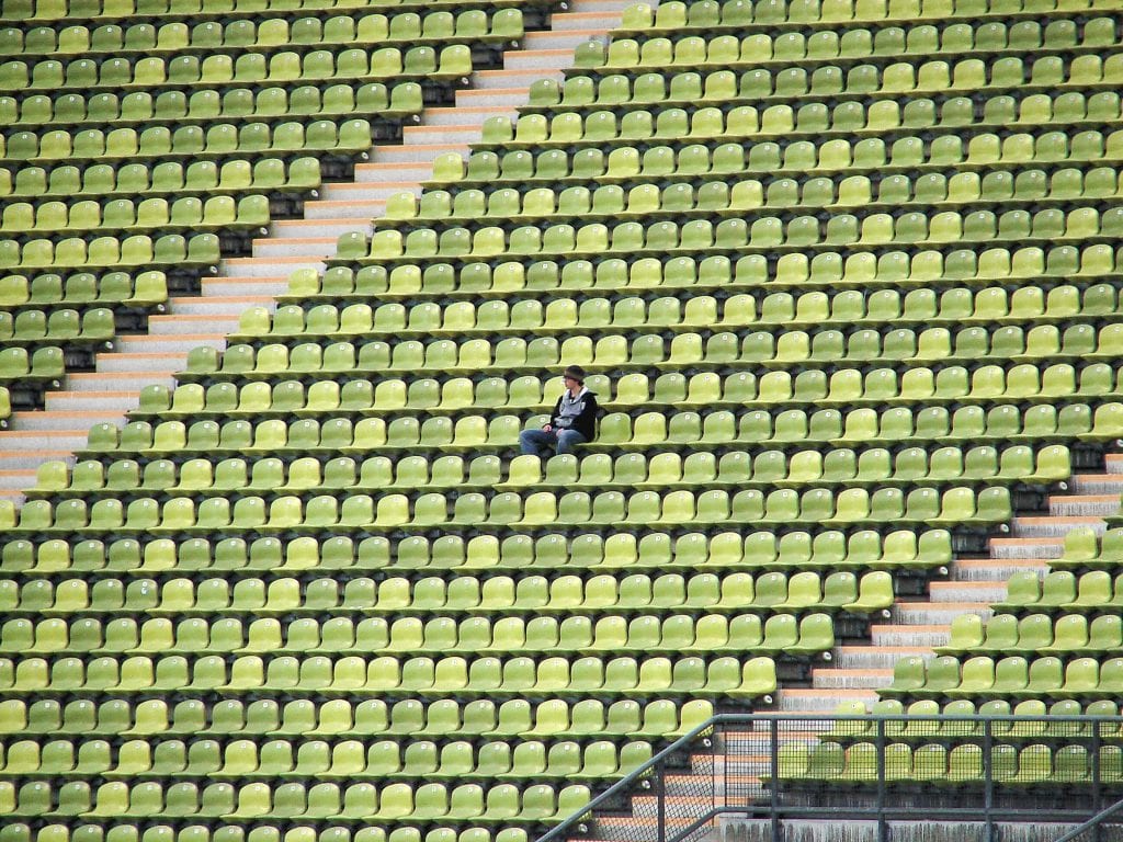 woman sitting alone in an empty stadium