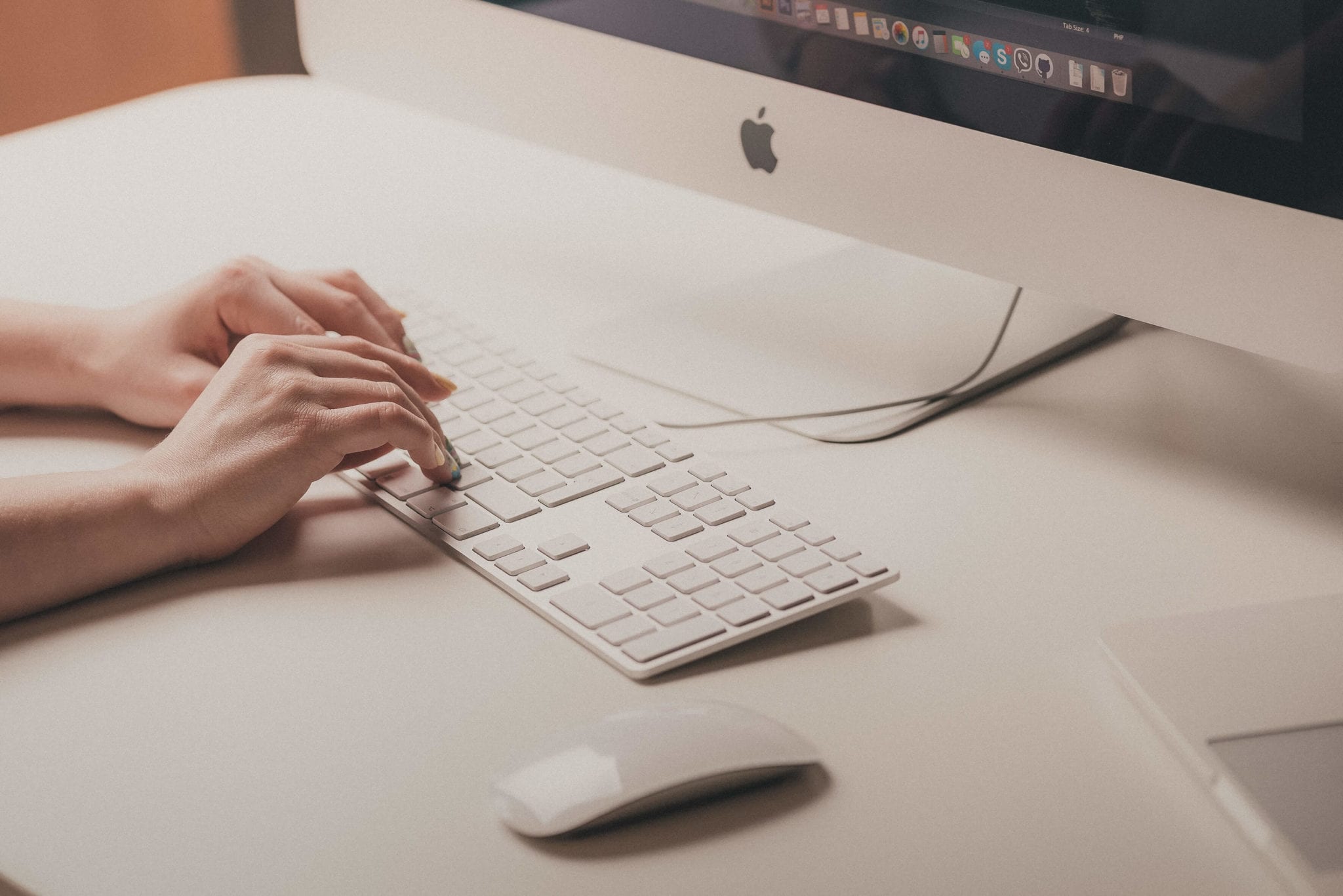 woman typing on apple mac computer keyboard