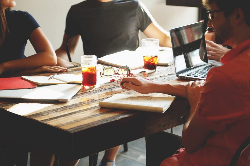 meeting men and women sitting at a table having an informal meeting
