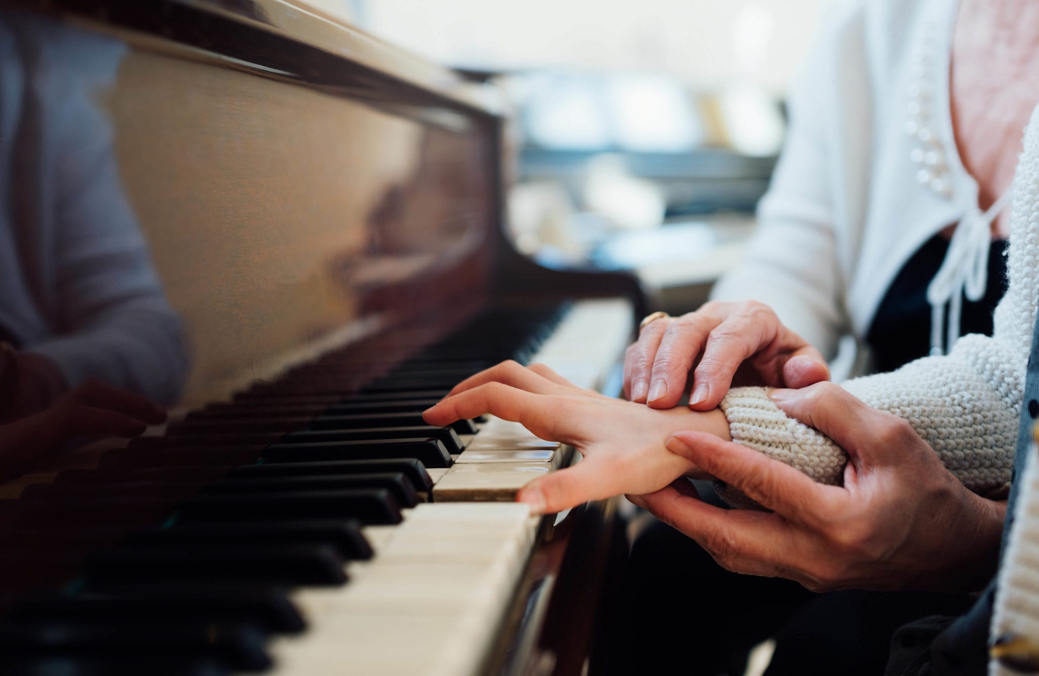 piano teacher helping young student