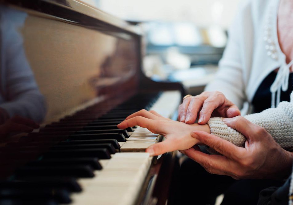 piano teacher helping young student